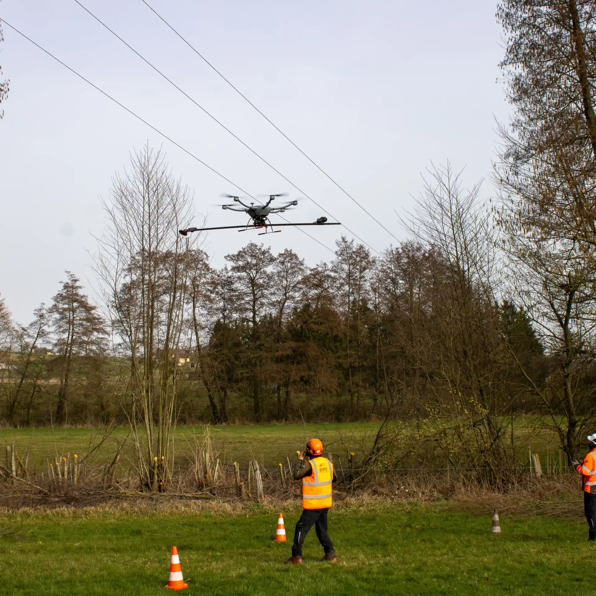 drone d'élagage et équipe technique près d'une ligne haute tension